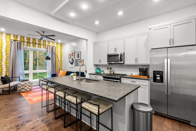 kitchen featuring a center island with sink, sink, a breakfast bar area, and stainless steel appliances