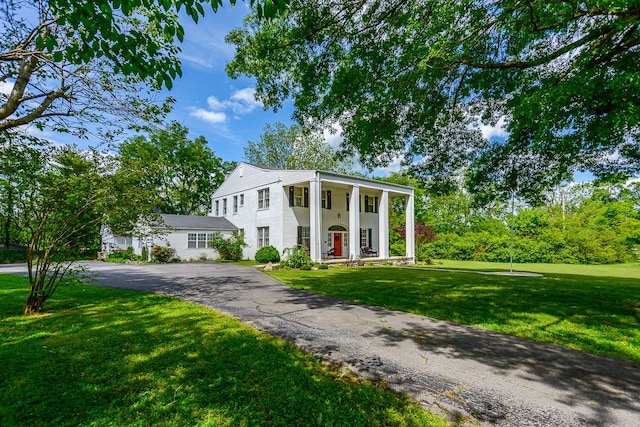 view of front of house with covered porch and a front yard