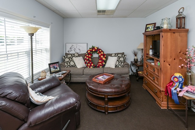 carpeted living room with a paneled ceiling