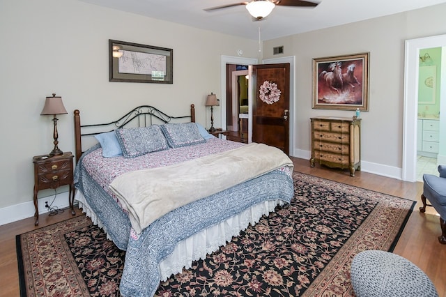 bedroom featuring wood-type flooring, ensuite bath, and ceiling fan