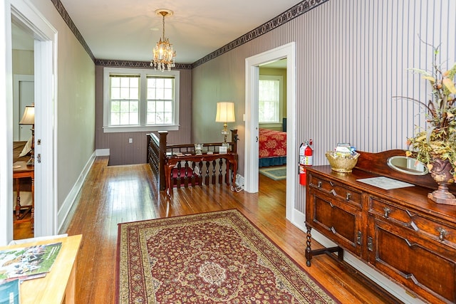 dining space with wood-type flooring and a chandelier