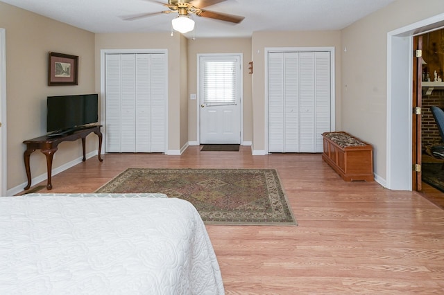 bedroom with multiple closets, ceiling fan, and light hardwood / wood-style floors