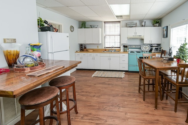 kitchen with sink, white cabinets, dark wood-type flooring, and white appliances