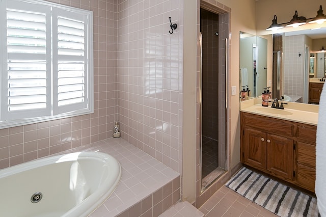 bathroom with tile patterned floors, vanity, and plus walk in shower