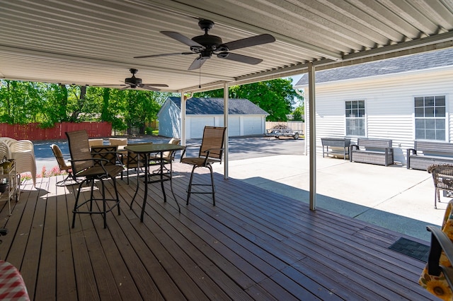 wooden terrace featuring ceiling fan and an outdoor structure