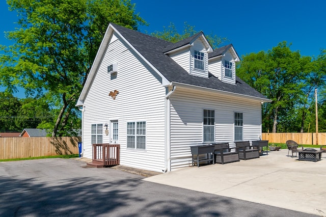 back of house with a fire pit and a patio area