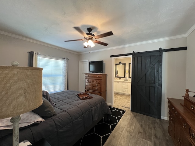 bedroom featuring crown molding, ceiling fan, a barn door, and wood-type flooring