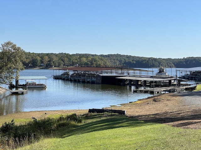 view of dock with a yard and a water view