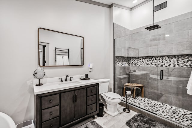 bathroom with an enclosed shower, vanity, and toilet