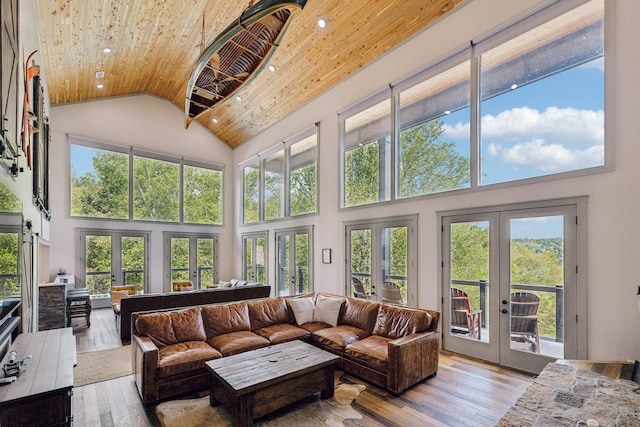 sunroom / solarium with vaulted ceiling, plenty of natural light, french doors, and wooden ceiling