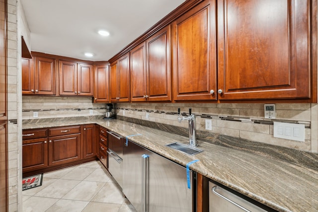 kitchen with light stone countertops, sink, light tile patterned floors, and tasteful backsplash