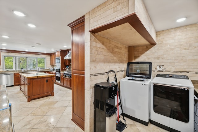 laundry area with light tile patterned floors, sink, and washer and dryer