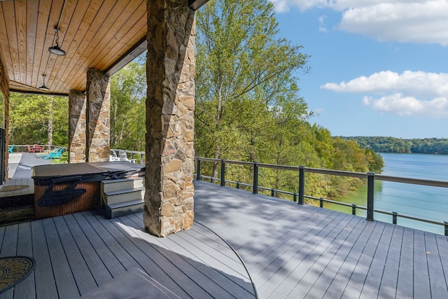 deck featuring a water view and a hot tub