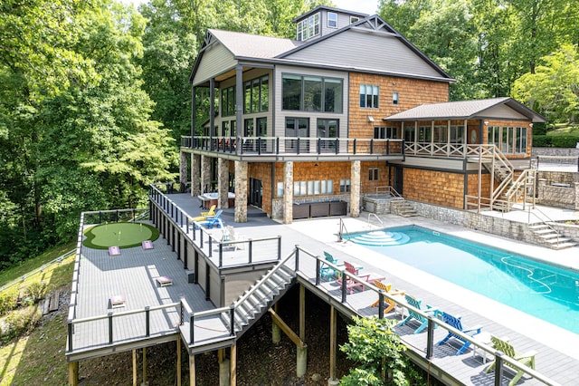 rear view of house featuring a sunroom, a pool side deck, and a patio area