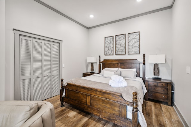 bedroom with ornamental molding, a closet, and hardwood / wood-style floors