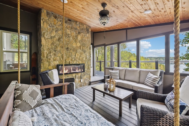 sunroom / solarium featuring lofted ceiling, a fireplace, and wooden ceiling