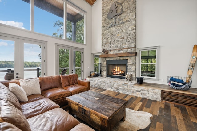 living room featuring a water view, french doors, and a high ceiling