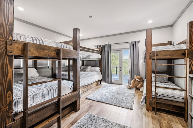 bedroom featuring crown molding, light hardwood / wood-style flooring, and access to outside