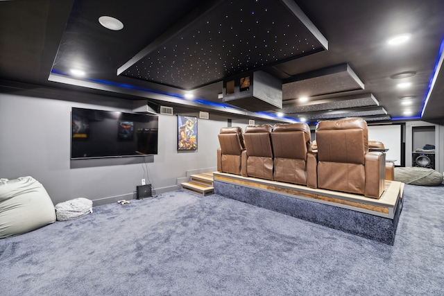 home theater featuring a tray ceiling and carpet flooring