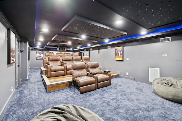 cinema room with a tray ceiling and carpet flooring