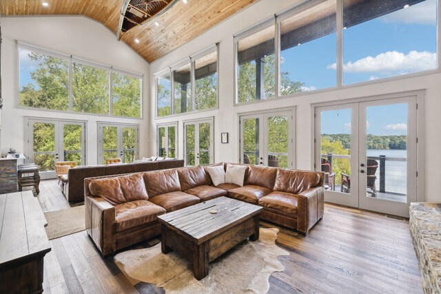 sunroom / solarium with a water view, a wealth of natural light, and french doors