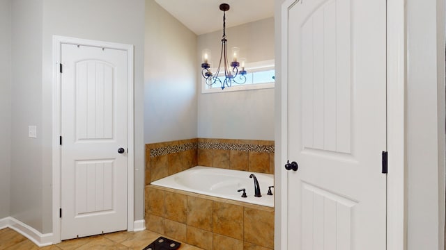 bathroom featuring tile patterned flooring, a chandelier, and tiled bath