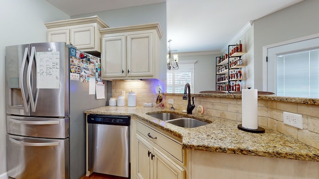 kitchen featuring sink, cream cabinets, appliances with stainless steel finishes, light stone countertops, and crown molding