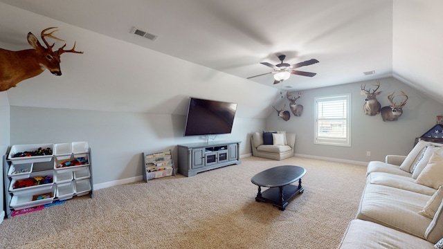 carpeted living room with ceiling fan and vaulted ceiling