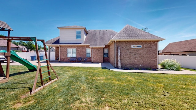 back of house featuring a playground, a lawn, and a patio