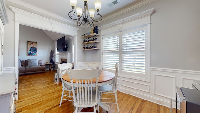 dining room featuring a notable chandelier, crown molding, and light hardwood / wood-style floors