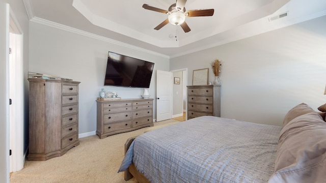 carpeted bedroom featuring ceiling fan, a tray ceiling, and crown molding