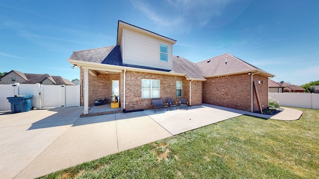 rear view of property featuring a lawn and a patio