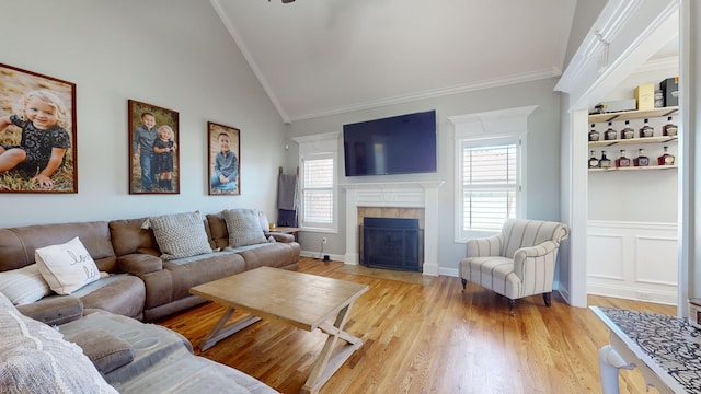 living room with ornamental molding, light wood-type flooring, and a healthy amount of sunlight