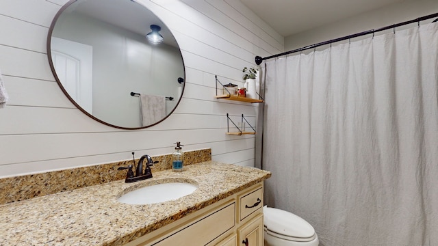 bathroom with wood walls, walk in shower, vanity, and toilet