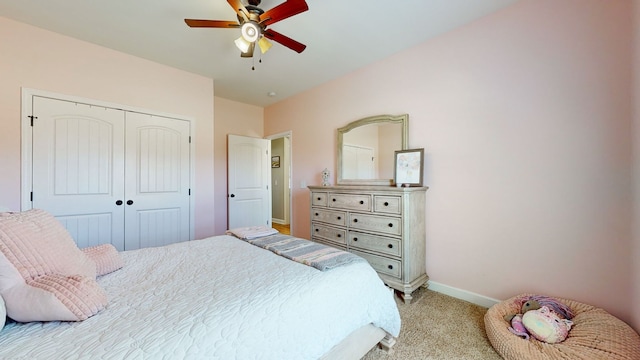 carpeted bedroom featuring ceiling fan and a closet