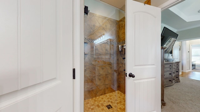 bathroom featuring a tile shower, crown molding, and vanity