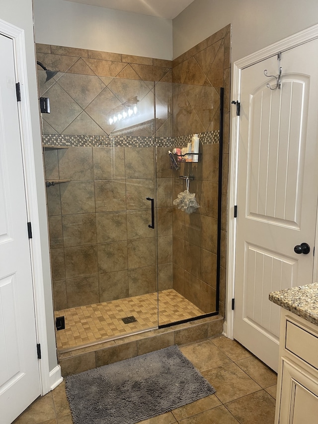 bathroom featuring an enclosed shower, tile patterned flooring, and vanity