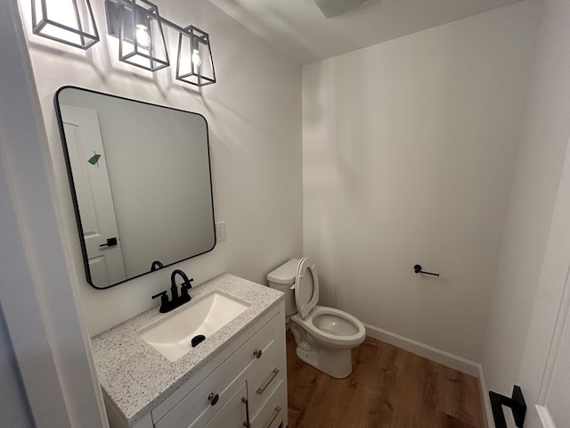 bathroom featuring hardwood / wood-style floors, vanity, and toilet