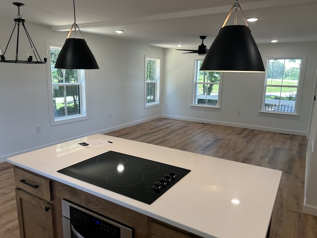 kitchen featuring a center island, dark hardwood / wood-style flooring, pendant lighting, stainless steel oven, and black electric stovetop