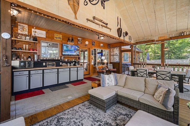 living room with wood ceiling, hardwood / wood-style floors, wooden walls, and a healthy amount of sunlight