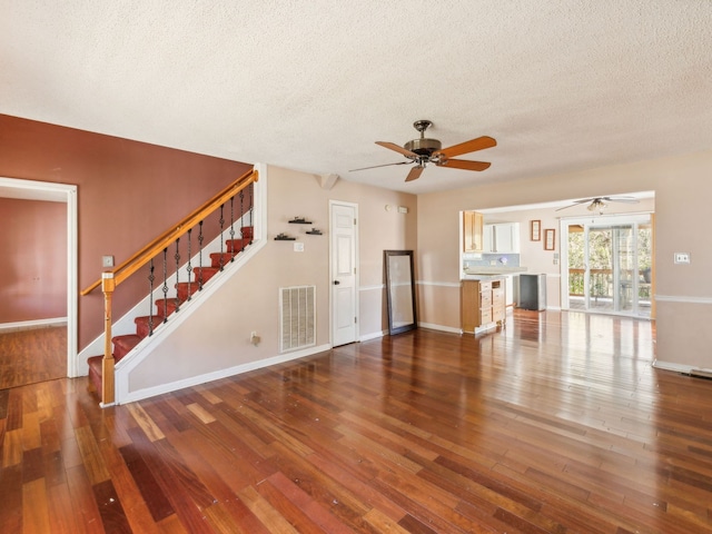 unfurnished living room with a textured ceiling, dark hardwood / wood-style floors, and ceiling fan