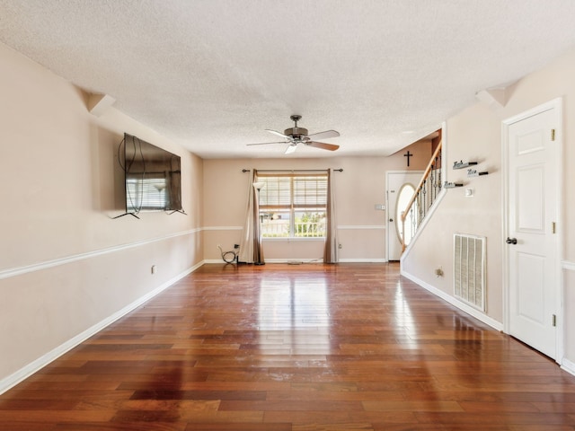 unfurnished living room with dark hardwood / wood-style floors, a textured ceiling, and ceiling fan