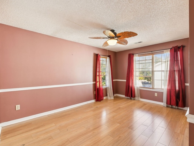 empty room featuring light hardwood / wood-style floors, a textured ceiling, and ceiling fan