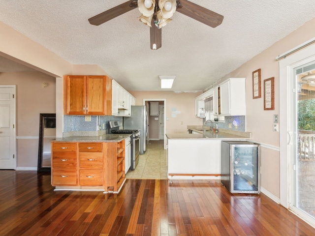 kitchen featuring hardwood / wood-style floors, a textured ceiling, stainless steel appliances, and backsplash