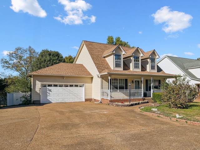 new england style home with covered porch and a garage