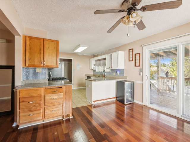 kitchen with sink, a textured ceiling, hardwood / wood-style flooring, and backsplash