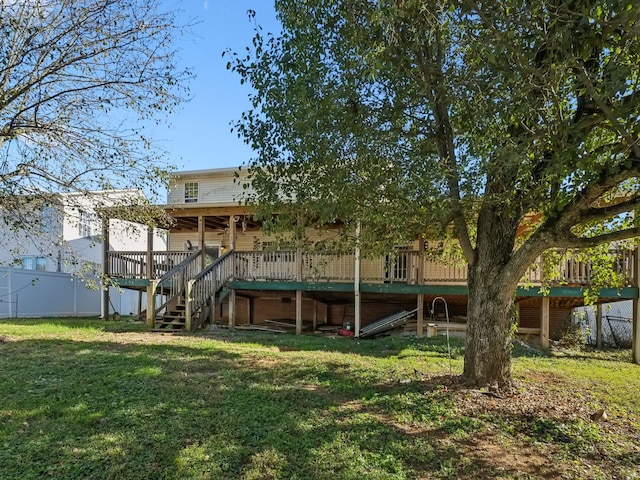 rear view of house featuring a wooden deck and a lawn