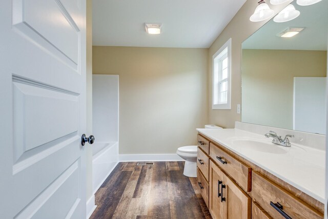 10890 Minor Hill Hwy, Goodspring, TN 38460 - bathroom featuring wood finished floors, toilet, vanity, baseboards, and a tub
