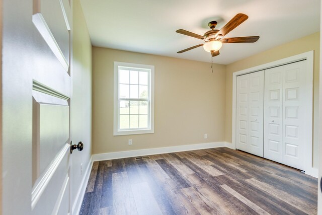 10890 Minor Hill Hwy, Goodspring, TN 38460 - unfurnished bedroom featuring dark wood-style floors, baseboards, a ceiling fan, and a closet