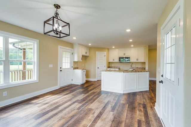 10890 Minor Hill Hwy, Goodspring, TN 38460 - kitchen with stainless steel microwave, dark wood-type flooring, white cabinets, baseboards, and a chandelier